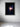 Framed artwork of a woman with glowing flowers against a dark background on a white wall.